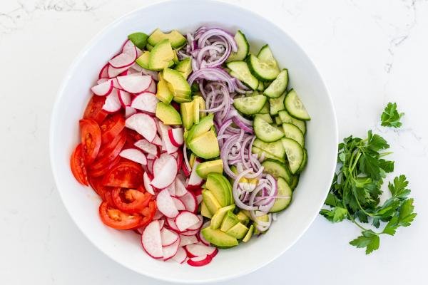 Salad in a bowl, tomatoes, radishes, avocado, onion and cucumber