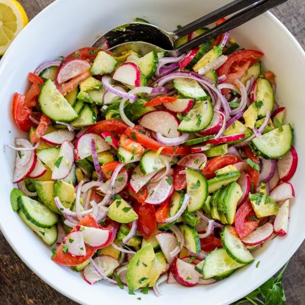 Salad in a bowl with seasoning, combined together