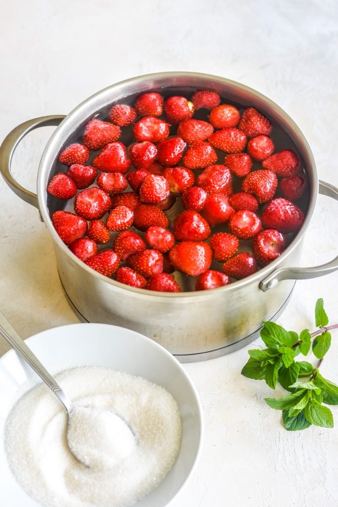 Kompot in a pot with sugar next to it