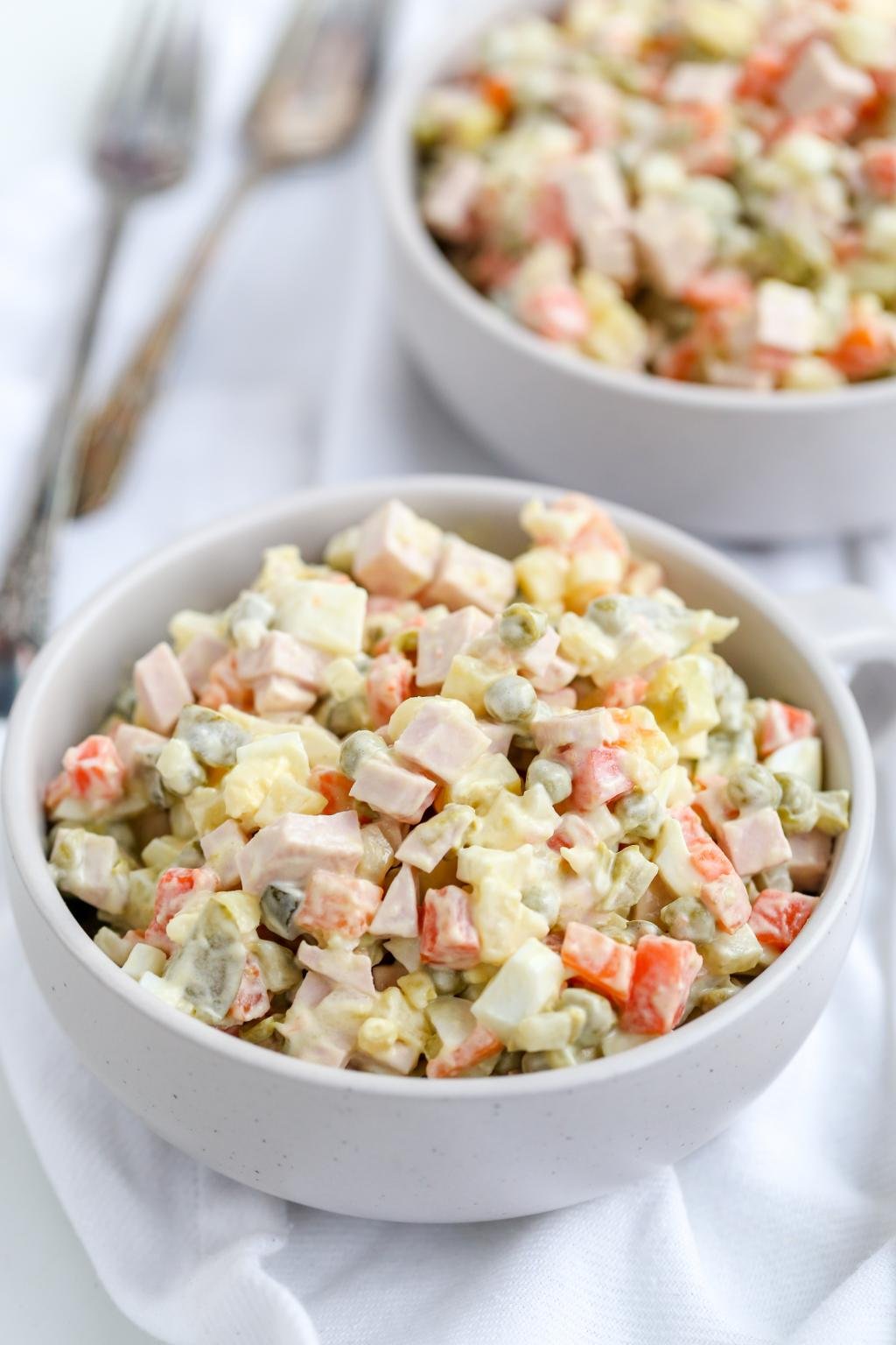 Russian Salad in a bowl, another bowl in background 