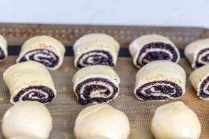 Rolled up dough with poppy seed filling on a baking sheet