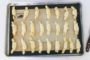 Unbaked rogaliki on a baking sheet
