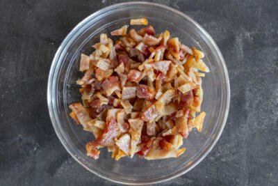 Cooked bacon in a bowl cut into pieces.