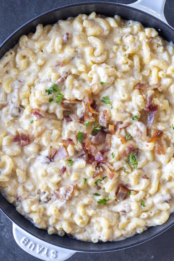 Smoky Bacon Macaroni and Cheese in a pan with herbs and bacon on top. 