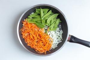 Carrots, onions and peas in a skillet