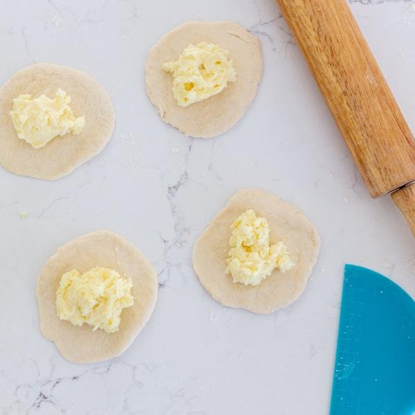 unformed piroshki with rolling pin and potato filling