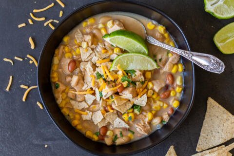 White Chicken Chili in a bowl with lime and chips