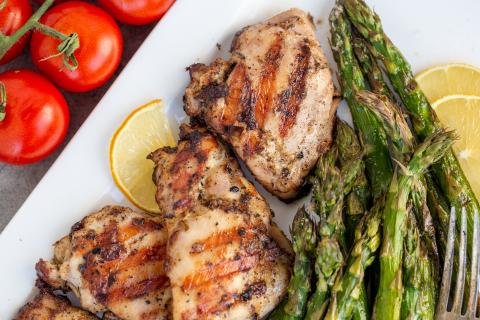 Grilled chicken on a tray with asparagus