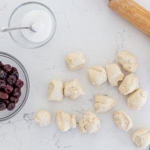 broken down dough with cherries and sugar