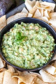 Guacamole in a bowl with chips around it