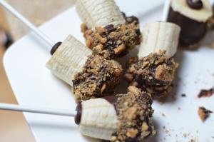 Chocolate dipped banana with walnuts on a plate