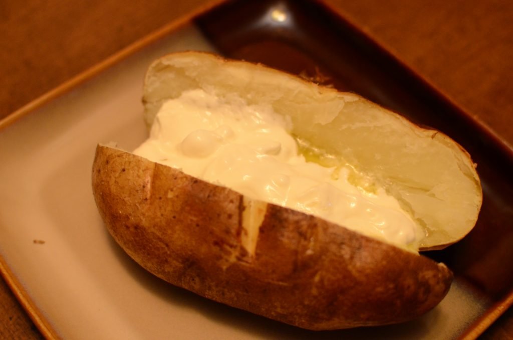 Baked potato with sour cream in it