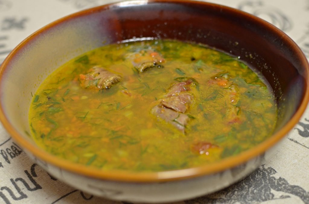 Lentil and pea soup with pork chops in a bowl on a table