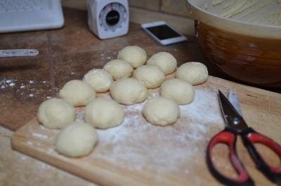 Round balls of dough rolled out and laid on a floured cutting board