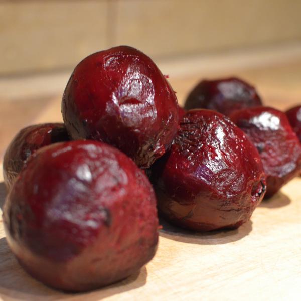 6 peeled and cooked beet on a cutting board