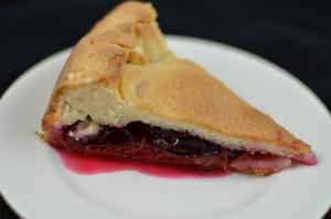A slice of plum pie on a plate