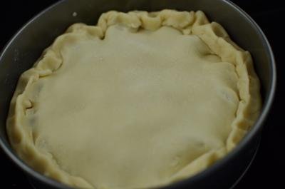 The top of the pie covered with dough and connected together with the sides of the pie