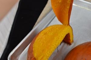 Pumpkin skin being peeled off pumpkin slice