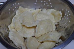 cooked pierogi in a drainer