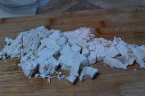 Chicken diced into small cubes on a cutting board