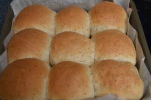 Baked quick wheat buns in a baking pan lined in parchment paper