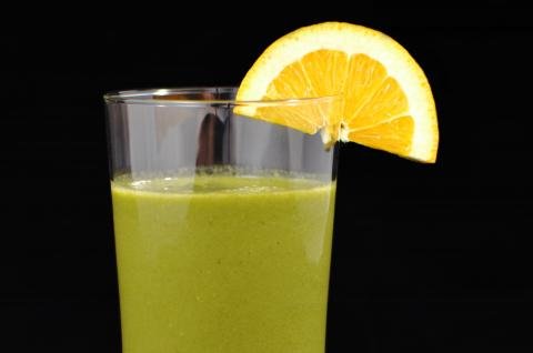 Green Smoothie with a orange slice on the brim of the glass