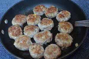 Meatballs frying in a skillet