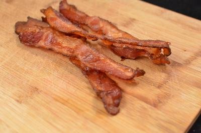 Cooked bacon slices on a cutting board