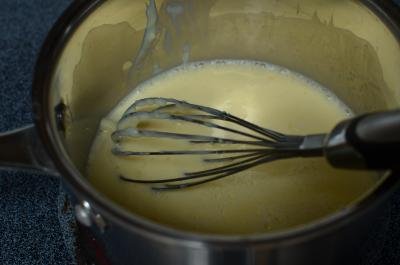 Whisked eggs, condensed milk and milk cooking on stove top