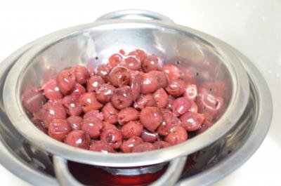 Cherries in a strainer with a bowl under