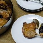 Roasted Duck with Prunes on a plate and a pan full of it next to the plate