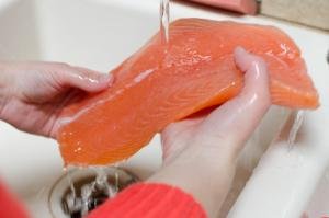 Rinsing salmon under the sink faucet
