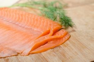 Salmon being sliced into thin, long strips