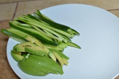 Avocado and cucumber cut into long thin strips and place on a plate