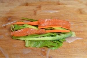 Lettuce, salmon, carrots, cucumbers and avocado in the middle of rice paper