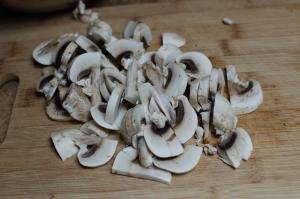 Mushrooms cut into fourths on a cutting board