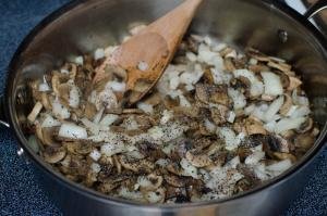 Mushrooms and onions being fried in a skillet