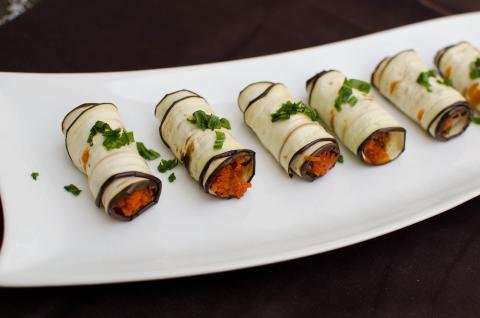Eggplant Roll Up Appetizer in a row on a plate