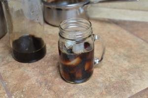 A mason jar like cup filled with coffee and ice