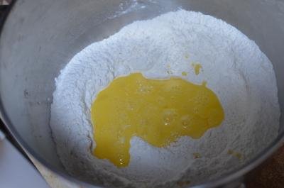 Flour, sugar, salt and yeast mixed in a bowl and in the center there are eggs and milk