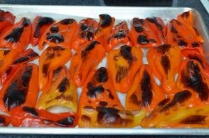 Roasted mini bell peppers cut in half and spread on a baking sheet