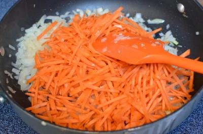Diced onions and carrots being sautéed on a skillet