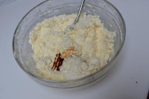 In a bowl a combination of farmers cheese, cream cheese, sugar, vanilla extract and egg yolk