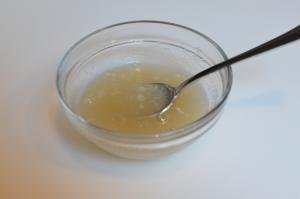 Gelatin and water mixed in a bowl with a spoon