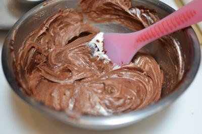Chocolate being mixed into the whipping cream mixture in a bowl