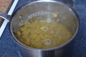 Macaroni being cooked in a pot over the stove top