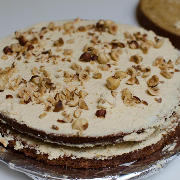 Sponge cake layer with cream and hazelnuts on top