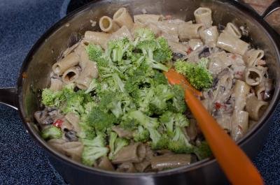 Whipping cream, garlic and broccoli added into the skillet with pasta