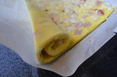Omelette Roll mixture being rolled into a long roll