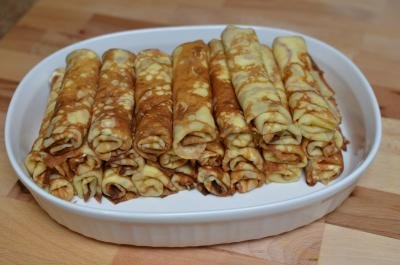 Crepes rolled up and stacked in a bowl